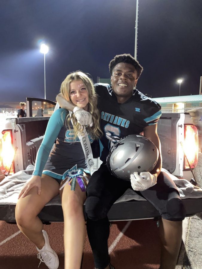 Senior homecoming royalty nominees Courtnie Barlow and John Agounke gets ready to drive around the field on homecoming float during halftime.