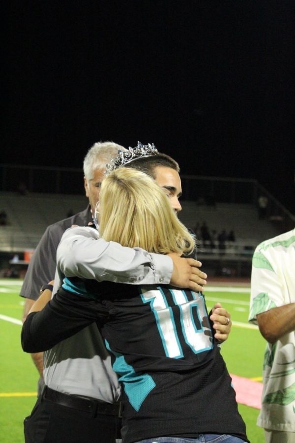 After the announcement of homecoming court winners during halftime on Oct. 1, Principal Jaime Ditto congratulates John Hooper after winning senior homecoming king. 