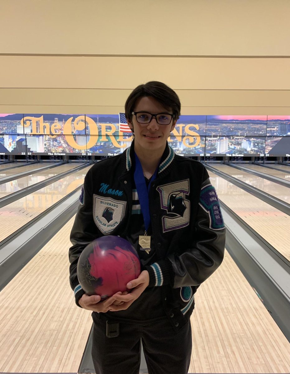Wearing his lettermans jacket, Mason Snow shows off his favorite bowling ball.