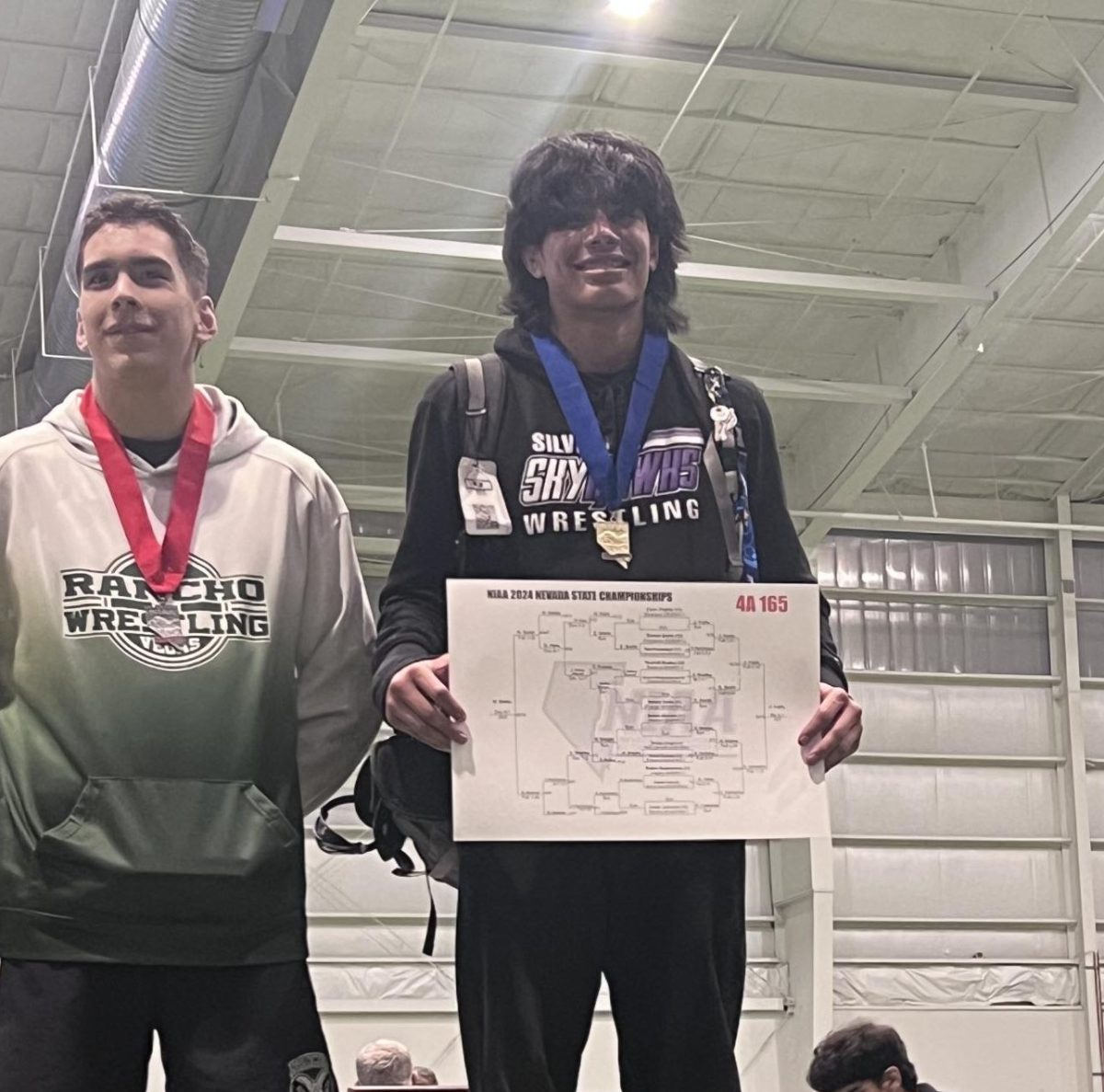 Zyon+Trujillo+proudly+stands+on+the+podium+at+state+championships+after+winning+first+place+in+his+weight+class+on+Friday+Feb.+16.