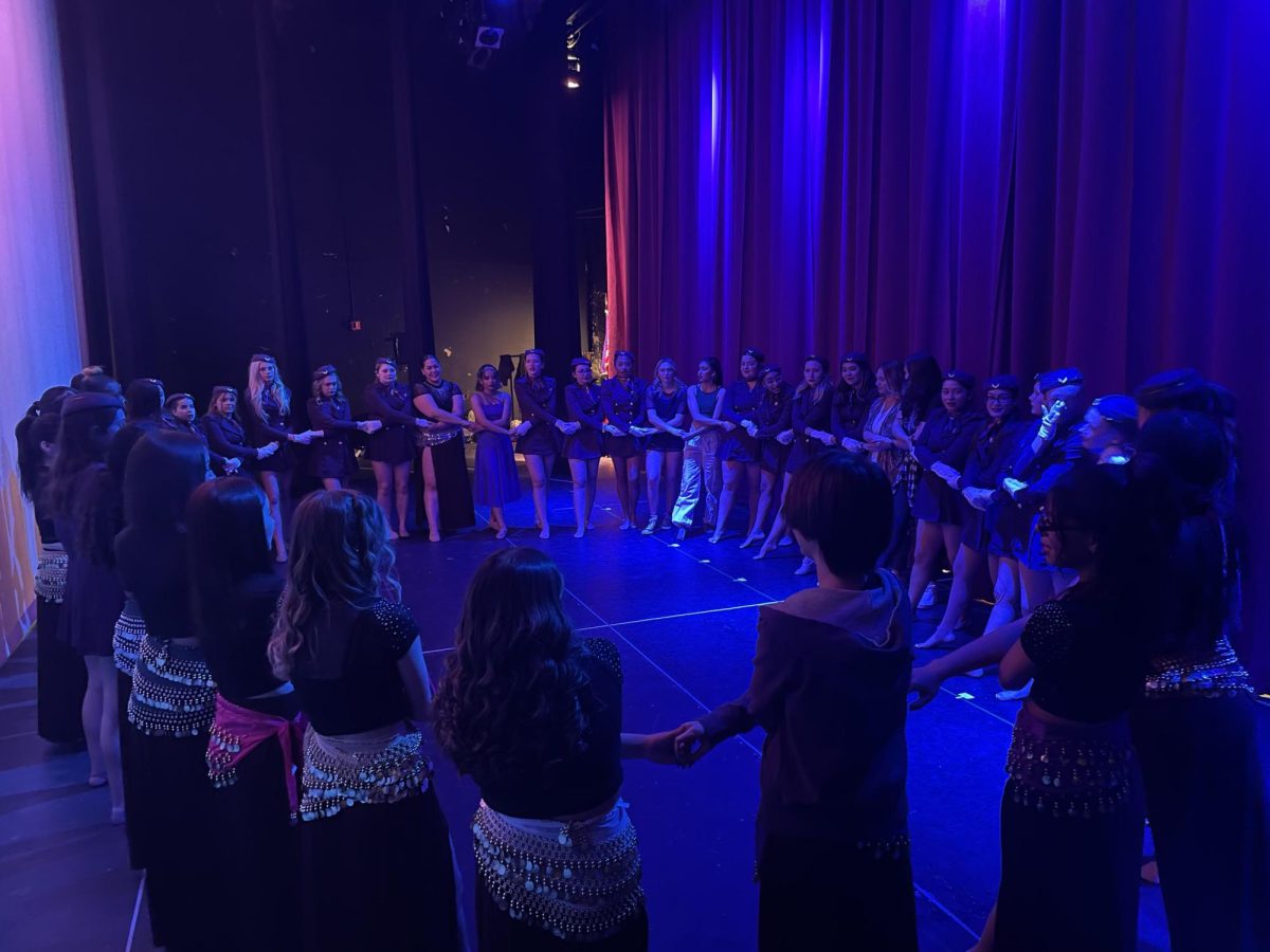 The Dance Team and Dance Company make their traditional circle on stage before the show on April 13.