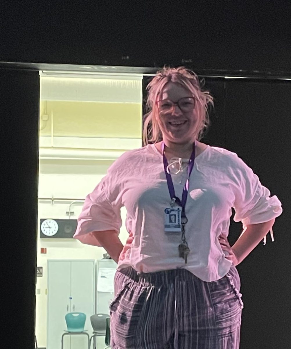 Megan Riedy stands smiling in the theater before it undergoes construction.